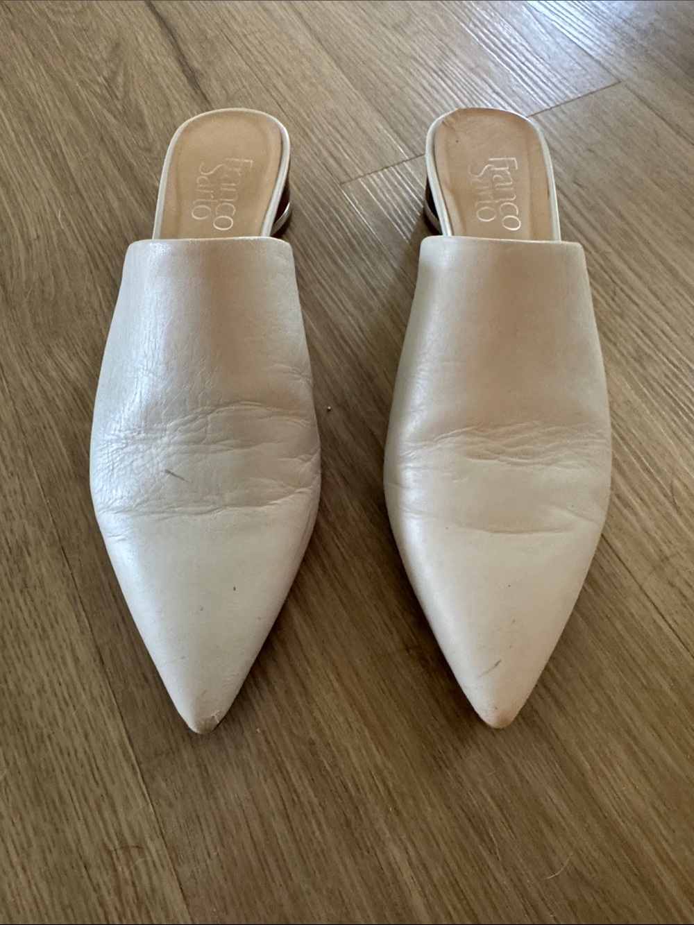 Franco Sarto Bone colored Leather Mules with gold accent on a wooden heal.